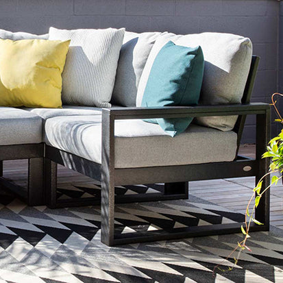 A black and yellow sectional sofa on a patio.