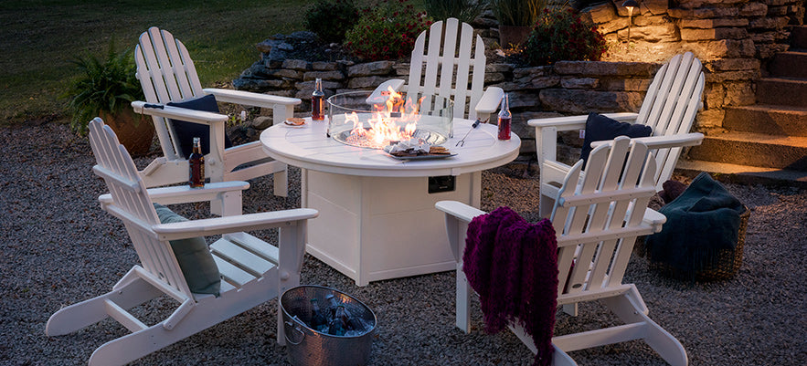 White adirondack chairs and a fire pit.