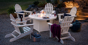 White adirondack chairs with a fire pit.