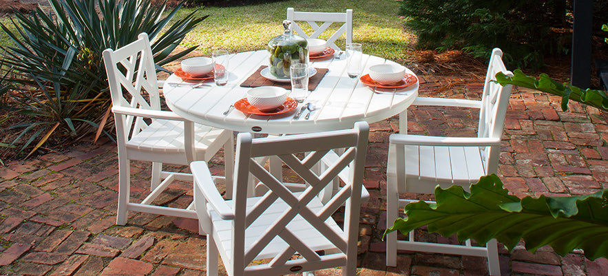 A white table and chairs in a garden.