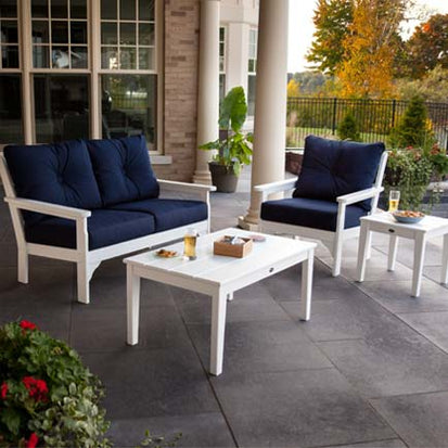 A white patio furniture set with blue cushions.